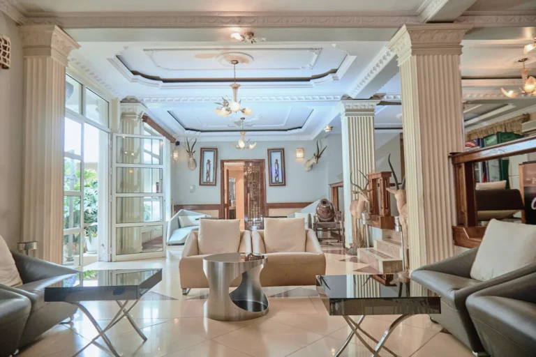 Bright lounge with columns, sofas and glass doors to the garden